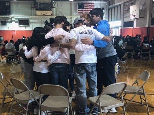 A group of students huddle together on Junior Day